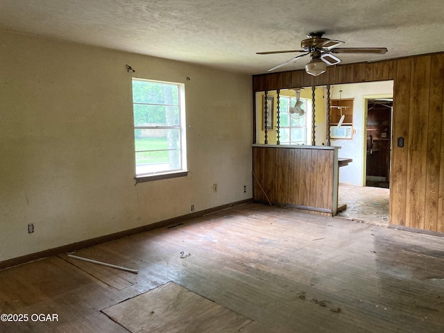 402 N Connor Ave, Joplin, MO 64801 - unfurnished living room with a ceiling fan, baseboards, wood finished floors, a textured ceiling, and cooling unit