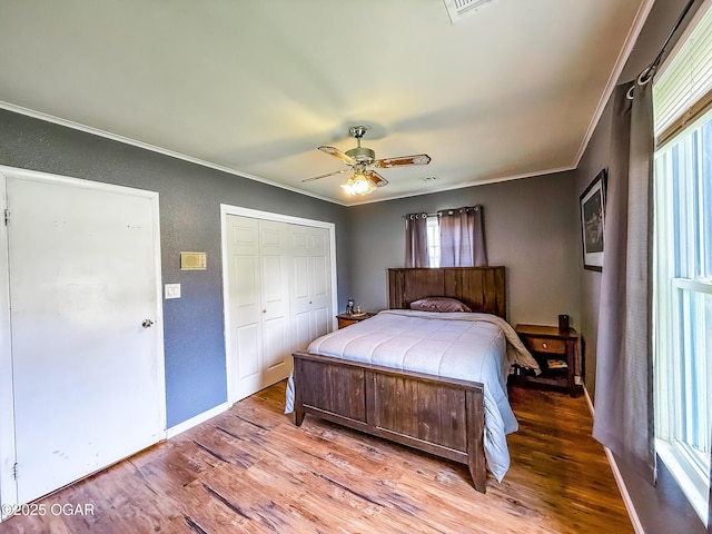 706 E Centennial E, Centennial, Pittsburg, KS 66762 - bedroom featuring crown molding, wood finished floors, a textured wall, a closet, and baseboards
