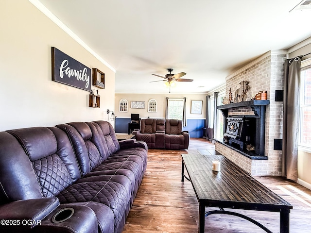 706 E Centennial E, Centennial, Pittsburg, KS 66762 - living area with wood finished floors, a ceiling fan, a fireplace, and ornamental molding