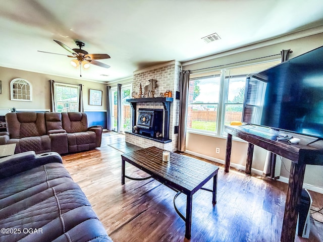 706 E Centennial E, Centennial, Pittsburg, KS 66762 - living area featuring wood finished floors, a ceiling fan, crown molding, baseboards, and a brick fireplace