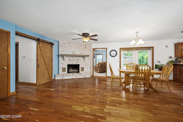 3431 Hawthorn Dr, Joplin, MO 64804 - dining area with wood finished floors, a chandelier, a ceiling fan, a brick fireplace, and a barn door