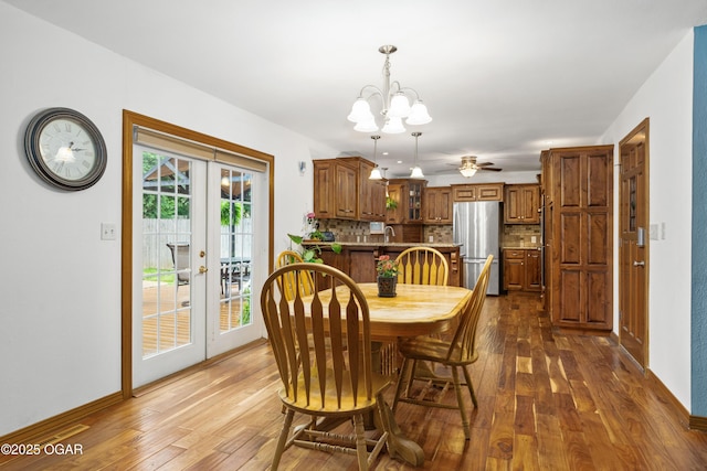 3431 Hawthorn Dr, Joplin, MO 64804 - dining space featuring french doors, dark wood-type flooring, a chandelier, and a ceiling fan