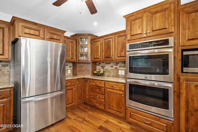 3431 Hawthorn Dr, Joplin, MO 64804 - kitchen with appliances with stainless steel finishes, brown cabinets, a ceiling fan, and recessed lighting