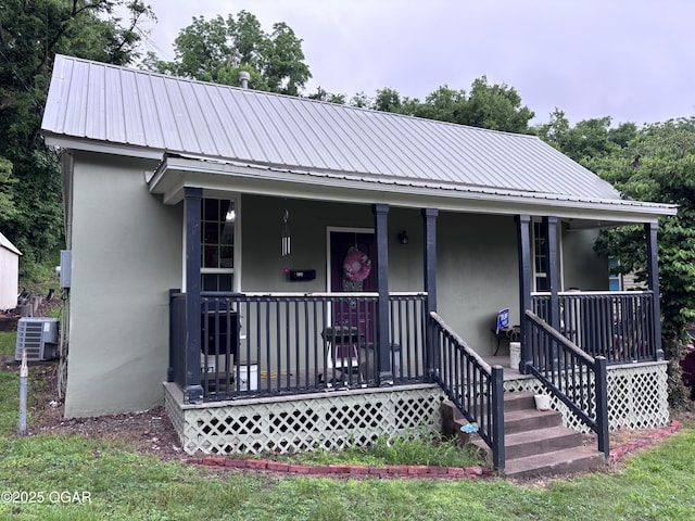 324 W Hill St, Neosho, MO 64850 - view of front of home featuring stucco siding, covered porch, central AC, and metal roof