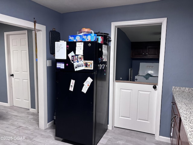 324 W Hill St, Neosho, MO 64850 - kitchen with freestanding refrigerator, washer / clothes dryer, baseboards, and light wood-style flooring
