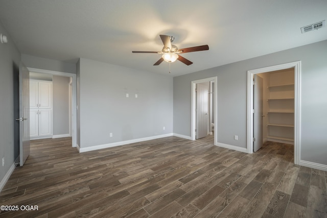 1704 Texas Ave, Joplin, MO 64804 - unfurnished bedroom with dark wood-style floors, a spacious closet, baseboards, and a ceiling fan