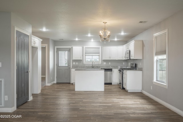 1704 Texas Ave, Joplin, MO 64804 - kitchen featuring appliances with stainless steel finishes, a chandelier, white cabinetry, and dark wood-style floors
