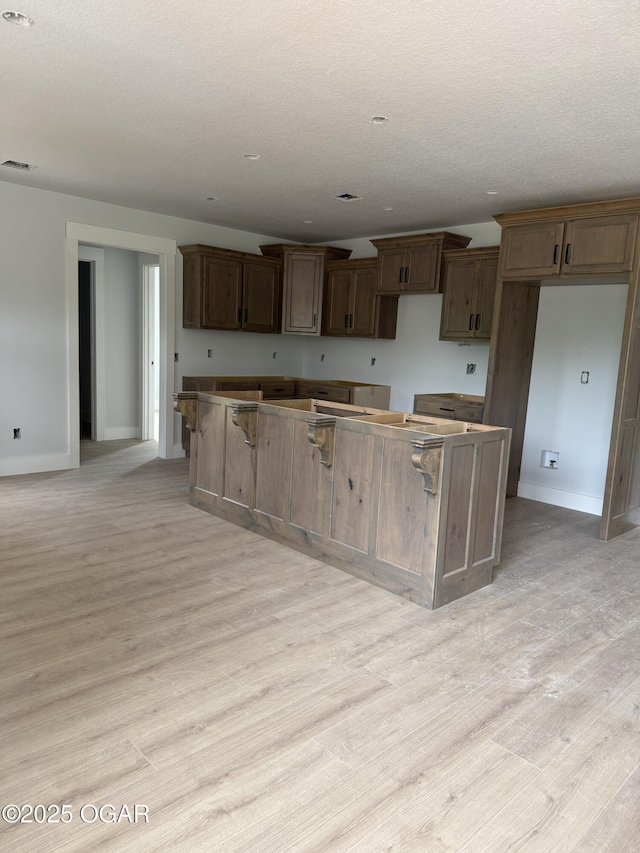 2006 E Quincy St, Joplin, MO 64801 - kitchen featuring a kitchen island, baseboards, and light wood finished floors