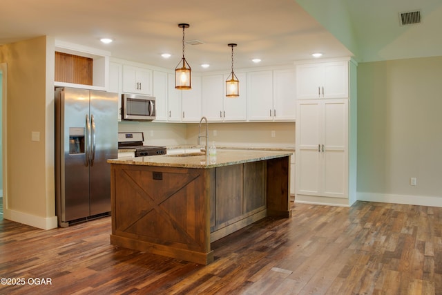 1002 S Mill St, Grove, OK 74344 - kitchen with stainless steel appliances, a sink, dark wood-style flooring, baseboards, and white cabinetry
