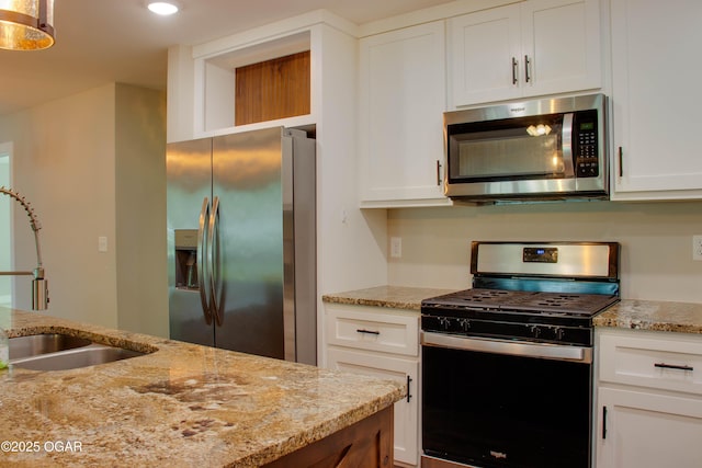 1002 S Mill St, Grove, OK 74344 - kitchen featuring stainless steel appliances, a sink, white cabinetry, light stone countertops, and recessed lighting