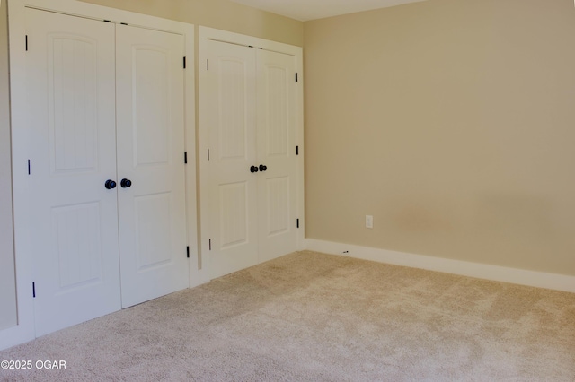 1002 S Mill St, Grove, OK 74344 - unfurnished bedroom featuring carpet and multiple closets
