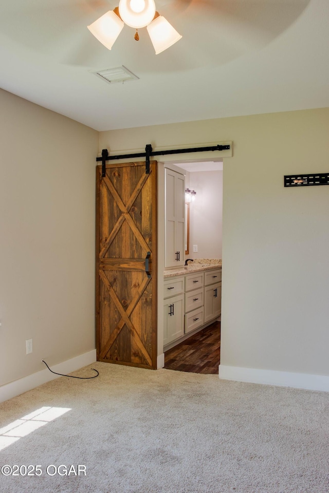1002 S Mill St, Grove, OK 74344 - unfurnished room featuring dark carpet, baseboards, and a barn door