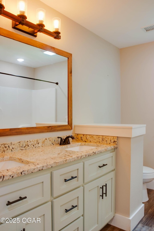 1002 S Mill St, Grove, OK 74344 - full bathroom with vanity, wood finished floors, toilet, a shower, and baseboards