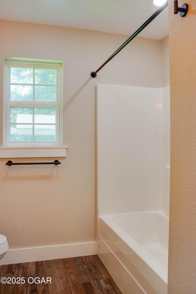 1002 S Mill St, Grove, OK 74344 - full bathroom with wood finished floors, toilet, shower / bathtub combination, and baseboards