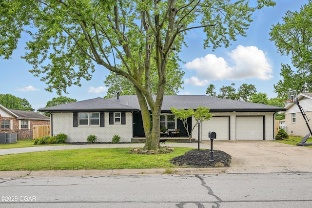 2722 Wisconsin Ave, Joplin, MO 64804 - ranch-style house with an attached garage, concrete driveway, cooling unit, and brick siding