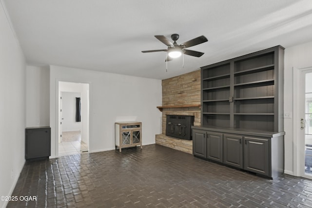 2722 Wisconsin Ave, Joplin, MO 64804 - unfurnished living room with ceiling fan, baseboards, a stone fireplace, and brick floors