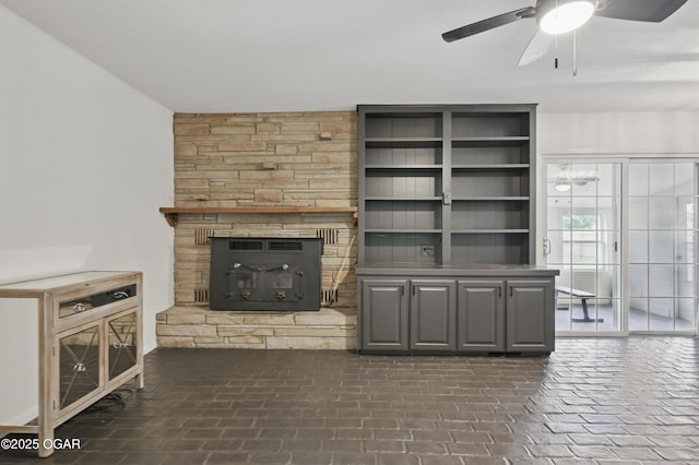 2722 Wisconsin Ave, Joplin, MO 64804 - unfurnished living room featuring ceiling fan, a stone fireplace, and brick floors