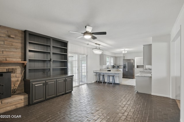 2722 Wisconsin Ave, Joplin, MO 64804 - living room featuring a ceiling fan, brick flooring, and baseboards