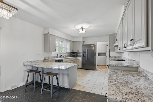 2722 Wisconsin Ave, Joplin, MO 64804 - kitchen with stainless steel appliances, a sink, a peninsula, under cabinet range hood, and a kitchen breakfast bar