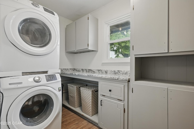 2722 Wisconsin Ave, Joplin, MO 64804 - washroom featuring cabinet space, estacked washer and dryer, and light wood finished floors