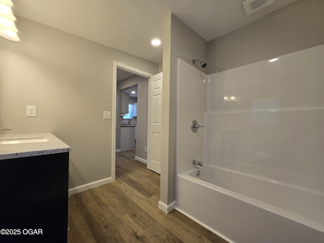 504 S Mckinley Ave, Joplin, MO 64801 - bathroom with wood finished floors, bathtub / shower combination, vanity, baseboards, and recessed lighting