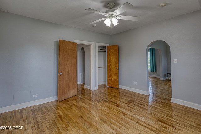 2502 S Tyler Ave, Joplin, MO 64804 - unfurnished bedroom featuring arched walkways, light wood-style floors, baseboards, and a closet