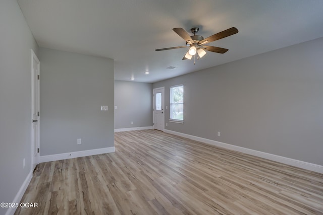 spare room with a ceiling fan and light wood finished floors