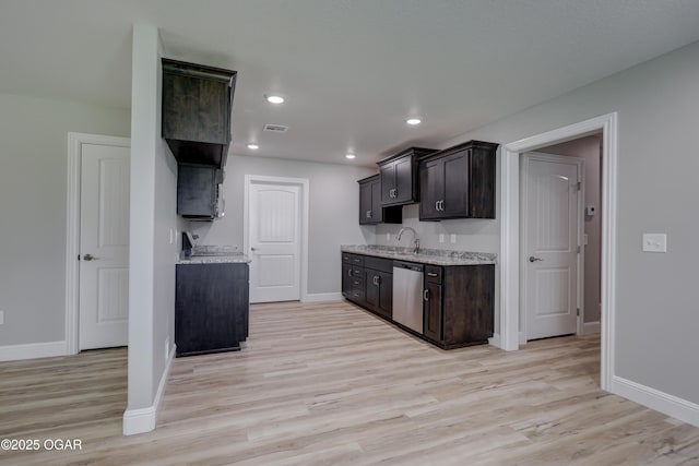 kitchen with stainless steel dishwasher, light wood-type flooring, light stone counters, dark brown cabinets, and recessed lighting