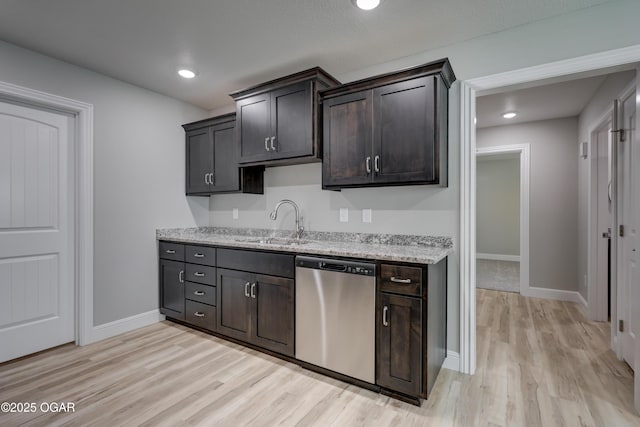 kitchen featuring stainless steel dishwasher, light wood finished floors, light stone counters, dark brown cabinets, and recessed lighting