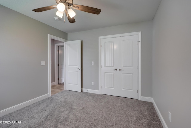 unfurnished bedroom with carpet, a closet, and a ceiling fan