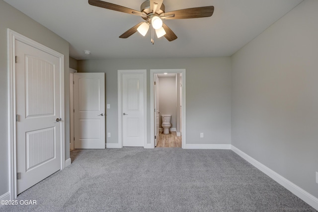 unfurnished bedroom featuring carpet floors, ensuite bath, and ceiling fan