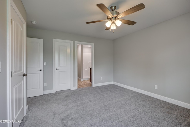 unfurnished bedroom with carpet floors, ceiling fan, and ensuite bathroom