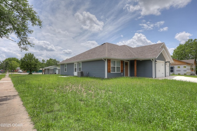 view of front of home with a garage, roof with shingles, and driveway