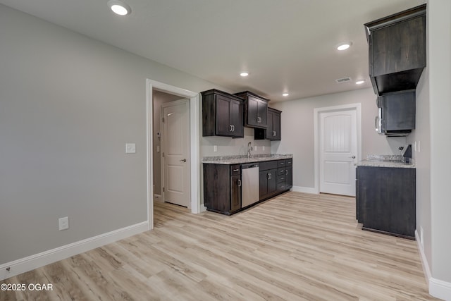 kitchen with stainless steel dishwasher, dark brown cabinets, light wood-style floors, recessed lighting, and light stone countertops
