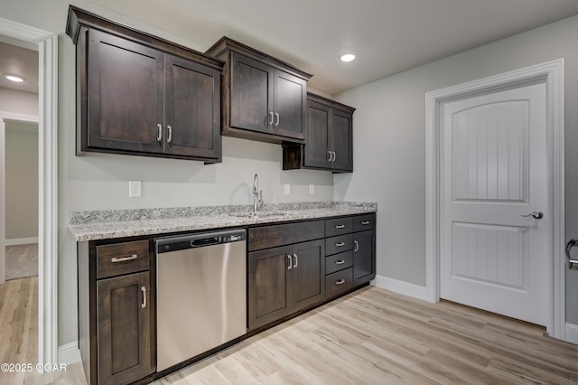 kitchen featuring dishwasher, light wood-type flooring, dark brown cabinets, light stone countertops, and recessed lighting
