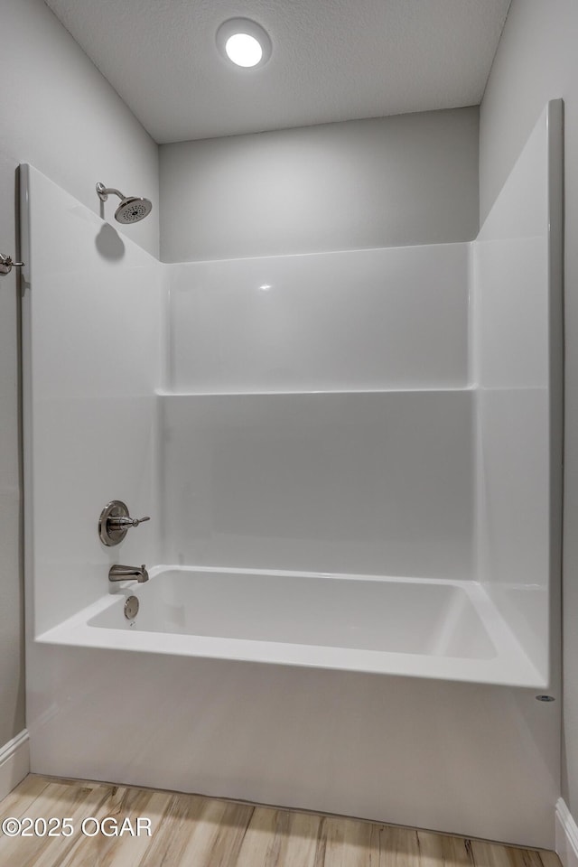 full bath featuring wood finished floors and tub / shower combination