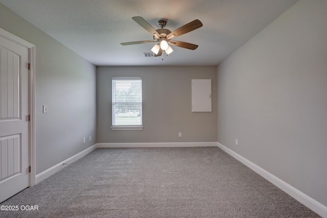 carpeted spare room with a ceiling fan and baseboards