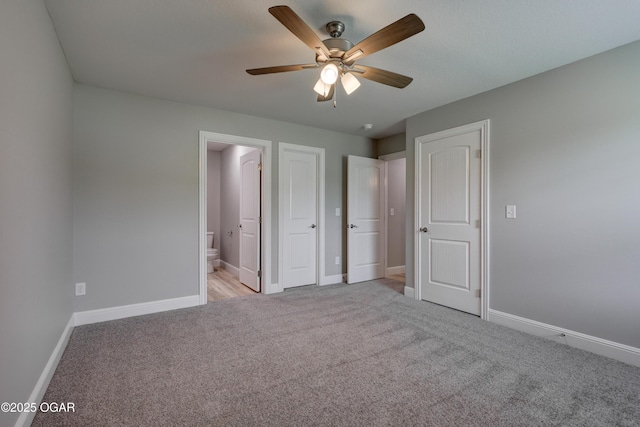 unfurnished bedroom with light colored carpet, connected bathroom, and a ceiling fan