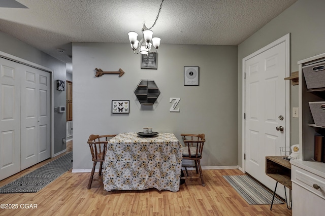 2413 Rolla St, Joplin, MO 64801 - dining room with a chandelier, light wood finished floors, a textured ceiling, and baseboards
