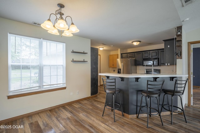 522 E Yale St, Liberal, MO 64762 - kitchen with black microwave, stainless steel fridge, healthy amount of natural light, and dark wood-style flooring
