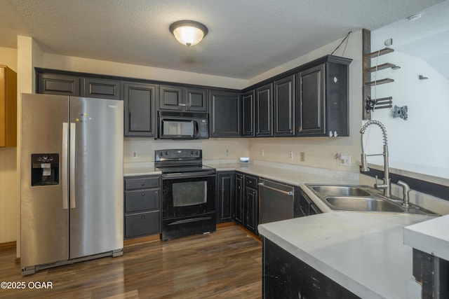 522 E Yale St, Liberal, MO 64762 - kitchen with black appliances, a sink, dark wood finished floors, light countertops, and a textured ceiling
