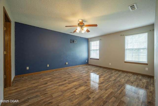 522 E Yale St, Liberal, MO 64762 - empty room with a ceiling fan, wood finished floors, baseboards, and a textured ceiling