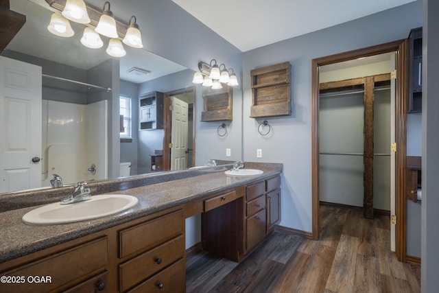 522 E Yale St, Liberal, MO 64762 - full bath with double vanity, wood finished floors, a shower, toilet, and baseboards