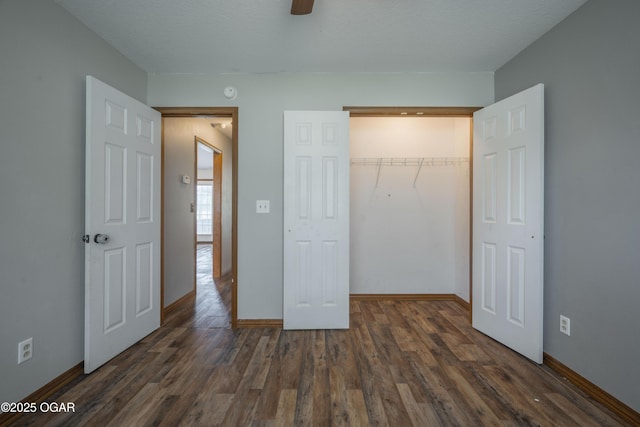 522 E Yale St, Liberal, MO 64762 - unfurnished bedroom featuring dark wood finished floors, baseboards, a closet, and ceiling fan