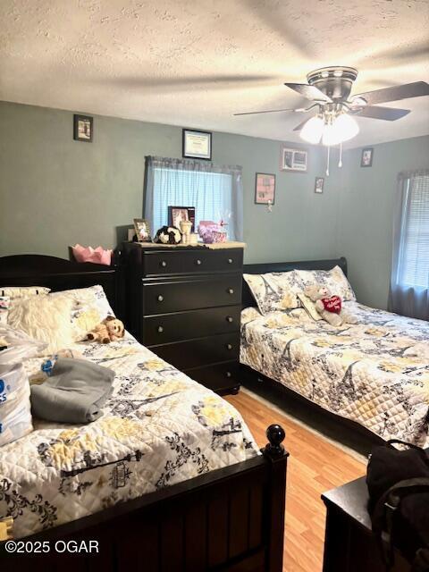 1300 S Baker Blvd, Carthage, MO 64836 - bedroom featuring a textured ceiling, light wood-type flooring, and ceiling fan