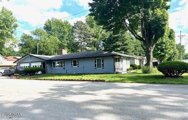 1300 S Baker Blvd, Carthage, MO 64836 - ranch-style house featuring an attached garage, a front yard, and a chimney