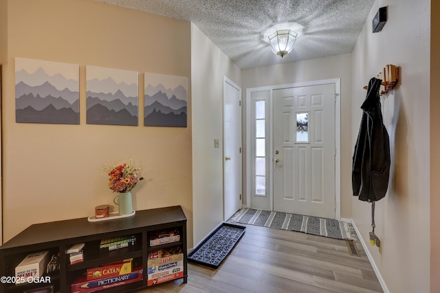 1241 Douglas Ct, Carthage, MO 64836 - foyer entrance featuring a textured ceiling, wood finished floors, and baseboards