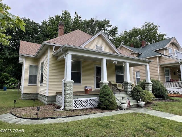 2022 S Jackson Ave, Joplin, MO 64804 - bungalow with covered porch, a front yard, a chimney, and roof with shingles