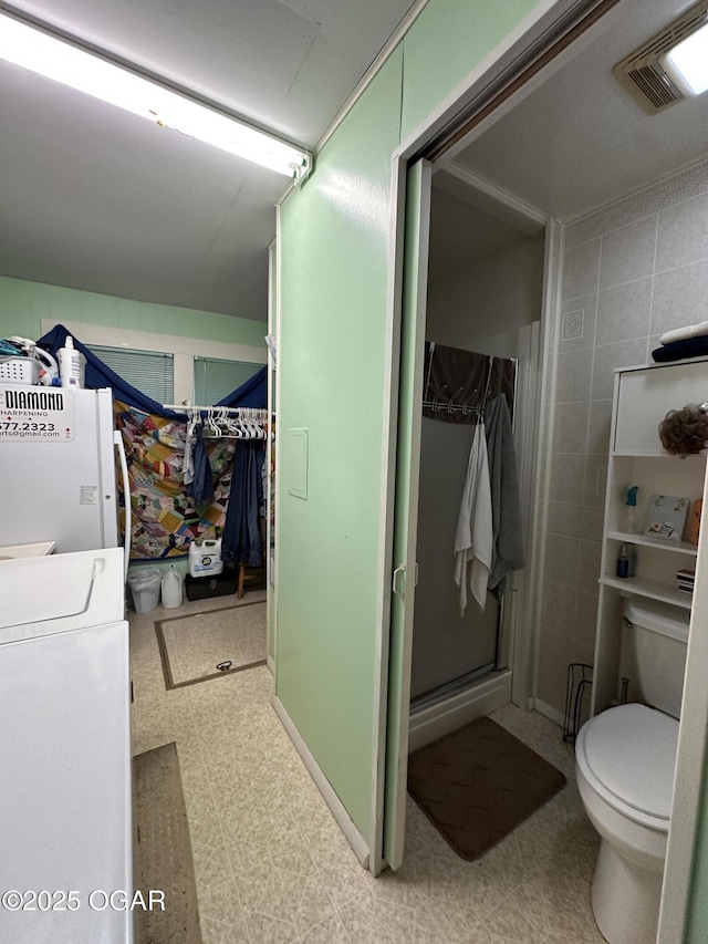 2022 S Jackson Ave, Joplin, MO 64804 - bathroom featuring tile patterned floors, a walk in closet, toilet, and a shower stall