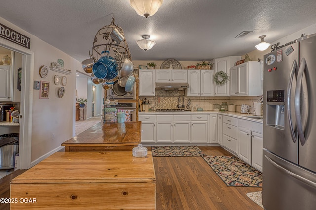 4430 E 26th St, Joplin, MO 64804 - kitchen featuring appliances with stainless steel finishes, under cabinet range hood, wood finished floors, white cabinets, and a textured ceiling